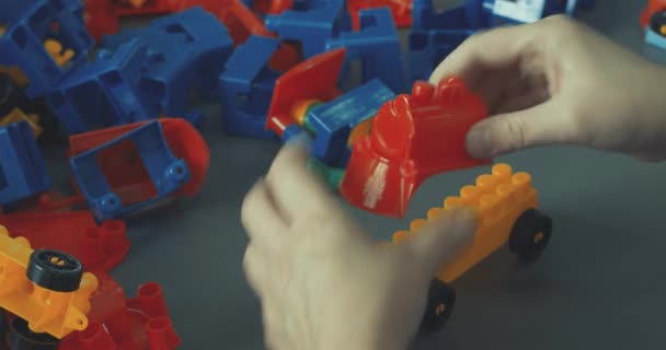 Meisjes handen verzamelen heldere plastic ontwerper close-up op de vloer van de kamer. Logisch denken. Ontwikkeling van kleuterschoolkinderen. — Stockvideo