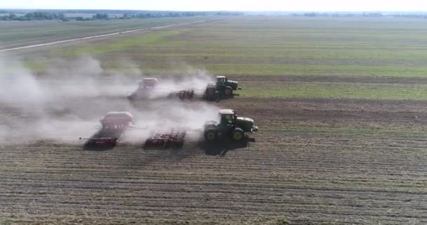 Plan glissant par drone d'un agriculteur en semis de tracteur, semant des cultures agricoles au champ — Video