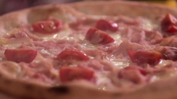 На столі стоїть смачна гаряча піца, крупним планом — стокове відео