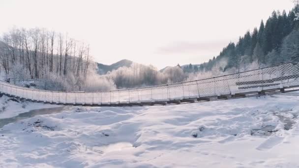Río de montaña y puente cubierto de nieve — Vídeos de Stock