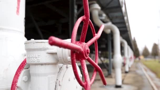 Válvula roja en la tubería para apagar líquidos, gas o aire en equipos industriales en plantas químicas y metalúrgicas . — Vídeos de Stock