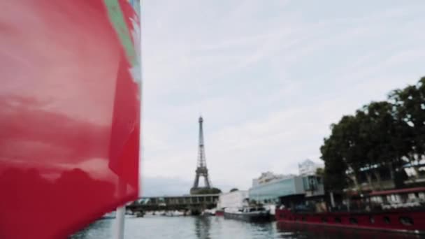Błyszcząca francuska flaga przymocowana do rufy łodzi motorowej na tle Wieży Elfela — Wideo stockowe