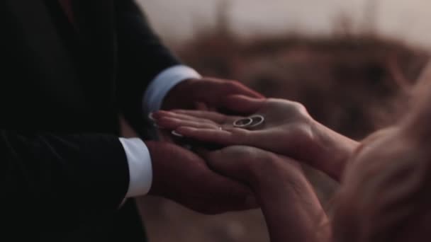 Nevěsta drží snubní prsteny na dlani, západ slunce, — Stock video