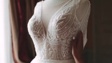 Gelin, gelinliğine romantik bir ışıkla dokunur..