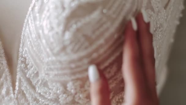 The bride touches her wedding dress in a bright romantic light. a detailed clan — Stock Video