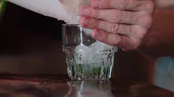 Verpletterd ijs raakt het glas, slow motion. Cocktailconcept. — Stockvideo