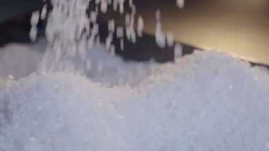 Tuz yavaşça kadınların ellerinden dökülür, ağır çekimde.