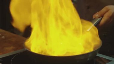 Şef ızgara tavada biftek fileto yapıyor. Mutfakta yemek var. Yemek pişirmek. Lezzetli yemek yanıyor.