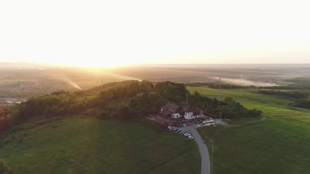 Flygfoto av ett hus, hotell på ett berg med en vacker solnedgång — Stockvideo