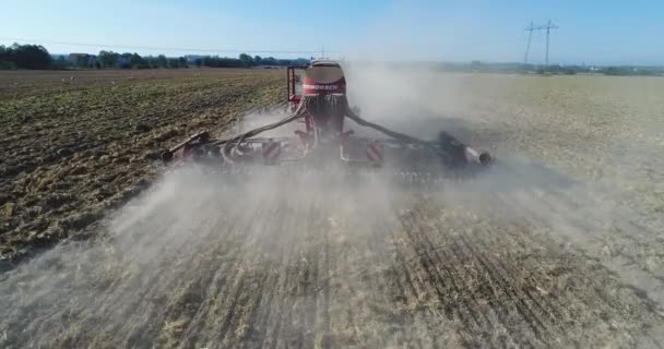 Za traktorem, který zavlažuje pole, létá kvadrokoptéra. pozadí — Stock video