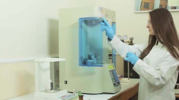 Mädchen im Labor legt Serumproben zur Analyse in ein medizinisches Gerät. Automatische biochemische Analyse. Innenräume. — Stockvideo