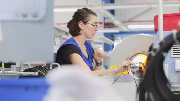 Dívka pracovník na speciální stroj kroutí elektroinstalace pro moderní automobily — Stock video