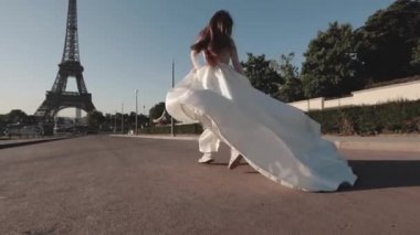 Genç gelin, Eiffel Kulesi 'nin arka planında ağır çekimde sallanan bir elbise ve uzun bir peçeyle koşuyor. Paris mi? Fransa