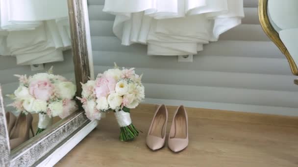 Primer plano de los detalles de la boda - zapatos y ramo. Ramo de bodas con tacones en el suelo. reflejo en el espejo. Concepto de moda, ceremonia, celebración y elegancia . — Vídeos de Stock