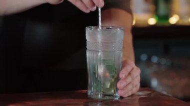 Barmen mojito kokteyli karıştırıyor. Barmen mojito pişiriyor.