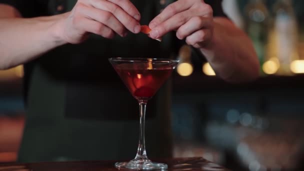 Barmen kokteyl dekoru için turuncu deriyi çeviriyor. — Stok video