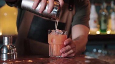Barmen süzgeçten döküyor. Tekila Gündoğumu. yakın plan