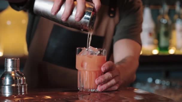 Le barman verse dans la passoire. Tequila Sunrise. gros plan — Video