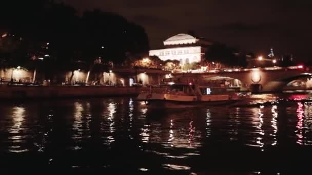 Op de voorgrond is een rivier van de zee en een boot. Gefilmd in de nacht. Parijs — Stockvideo