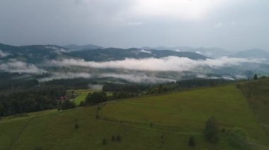 Dağların üzerinde beyaz sis. Dağların üzerinden bulutların ve sisin havadan görünüşü.