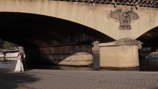 Наречені йдуть під мостом біля одинадцятої вежі в Парижі — стокове відео