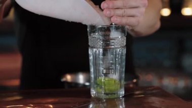 .Barmen limonlu bir bardağa ezilmiş buz doldurur. yakın plan