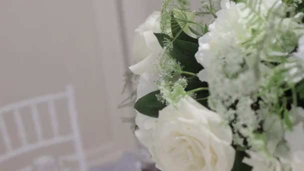 Bruiloft decoraties. Kleine witte bloemen op de tafel, mooi boeket. Een close-up. Bruiloft tafel decor — Stockvideo