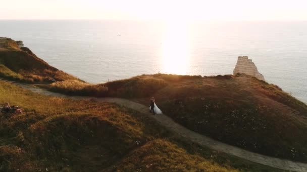 Linda selfie drone, jovens felizes recém-casados andando no topo da costa penhasco da Normandia oeste sobre o oceano. no fundo do oceano. câmara lenta — Vídeo de Stock