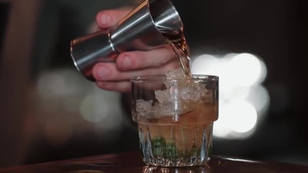 Bartender derrama coquetel de copo de medição em gelo com hortelã. Close-up. Mint Julep — Vídeo de Stock