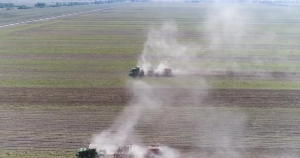 A câmera voa sobre dois tratores que trabalham no campo, vista aérea — Vídeo de Stock