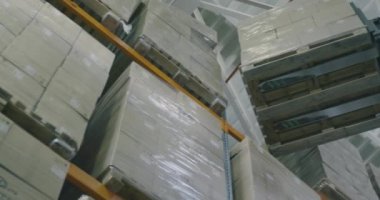 Forklift ürün kutularını depoya taşır, forklift kutuları yukarı kaldırır. RED CINEMA 'da çekilmiştir
