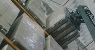 Forklift ürün kutularını depoya taşır, forklift kutuları yukarı kaldırır. Endüstriyel iç
