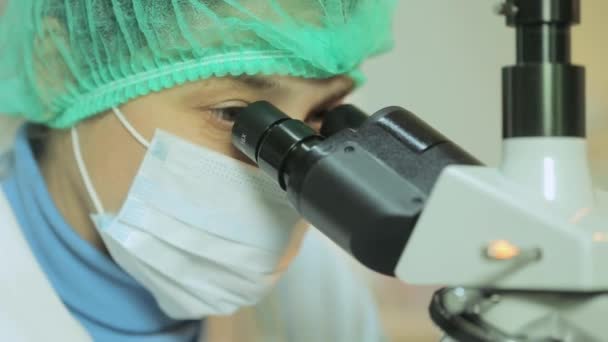 Mujer que trabaja en un laboratorio al microscopio de cerca — Vídeos de Stock