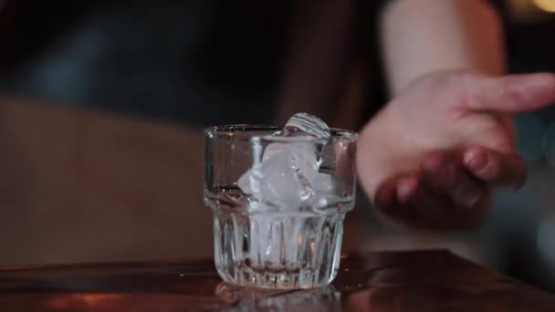 酒保把白色的鸡尾倒入一个装有冰块的杯子里。特写 — 图库视频影像