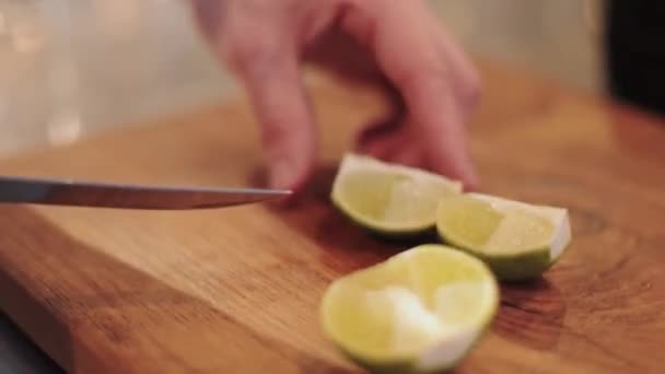 Mannelijke hand snijdt limoen, op bruin bord closeup, — Stockvideo