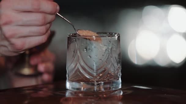 Gammaldags cocktail. Bartendern häller rörsocker i ett glas. Den officiella IBA cocktailen. Dags att dricka. — Stockvideo