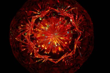 Kristalin yüzeyinde çok renkli ışık huzmeleri parlıyor.