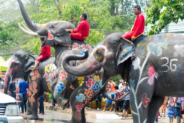 Reveladores e elefantes em água salpicando — Fotografia de Stock