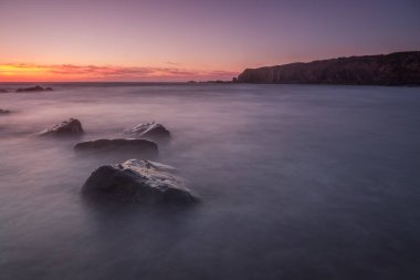 Sihirli deniz gün batımı manzarası. Suda kayıp taşlar..