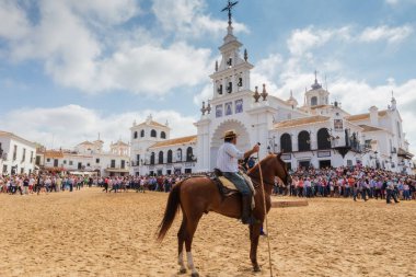 El ROCIO, ANDALUCIA, İspanya - 26 HAZİRAN 2016: Kilisenin yanındaki plaza, sürünün vaftiz edilmesini bekleyen atlı. Kalabalık izliyor..