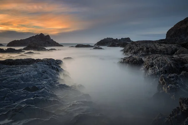 Kayaların Arasındaki Bulanık Denizlerde Gün Batımı — Stok fotoğraf