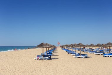 Tavira Adası sahilinde yaz sabahı. Kumdaki boş yataklar..