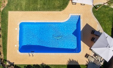 Aerial view of swimming pool outside hotel. Beautiful pool ready to holiday tourists. Top view. clipart