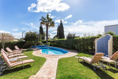 Güneş yatakları ve şilteler, dinlenmek için lüks havuzun yanında.