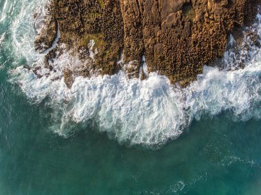 Havadan. Dalgalar gökyüzünden kayalara çarpıyor. Portekiz Algarve