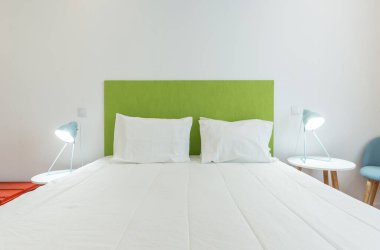 Yatak odası, yatak ve yastıklarla modern tarzda. Ön görünüm