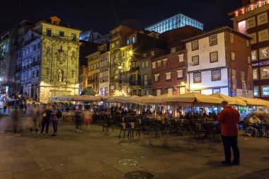 Porto 29 Eylül 2018: Turistler Porto, Cais da Ribeira 'nın gece caddelerinde yürüyorlar. San Luis köprüsünün yakınında.