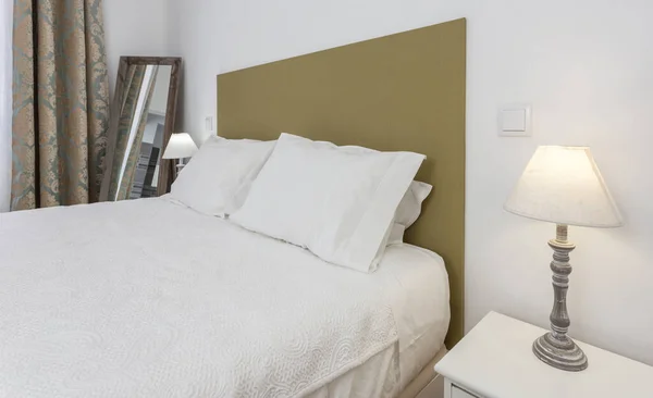 枕と読書用ランプ付きのモダンなベッド — ストック写真