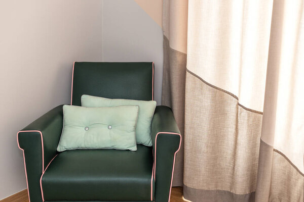 Soft leather chair in the room for rest, with pillows