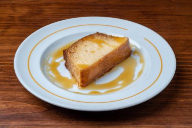 Bir dilim Portekiz tatlı karamel pudingi. Tahta bir masada.